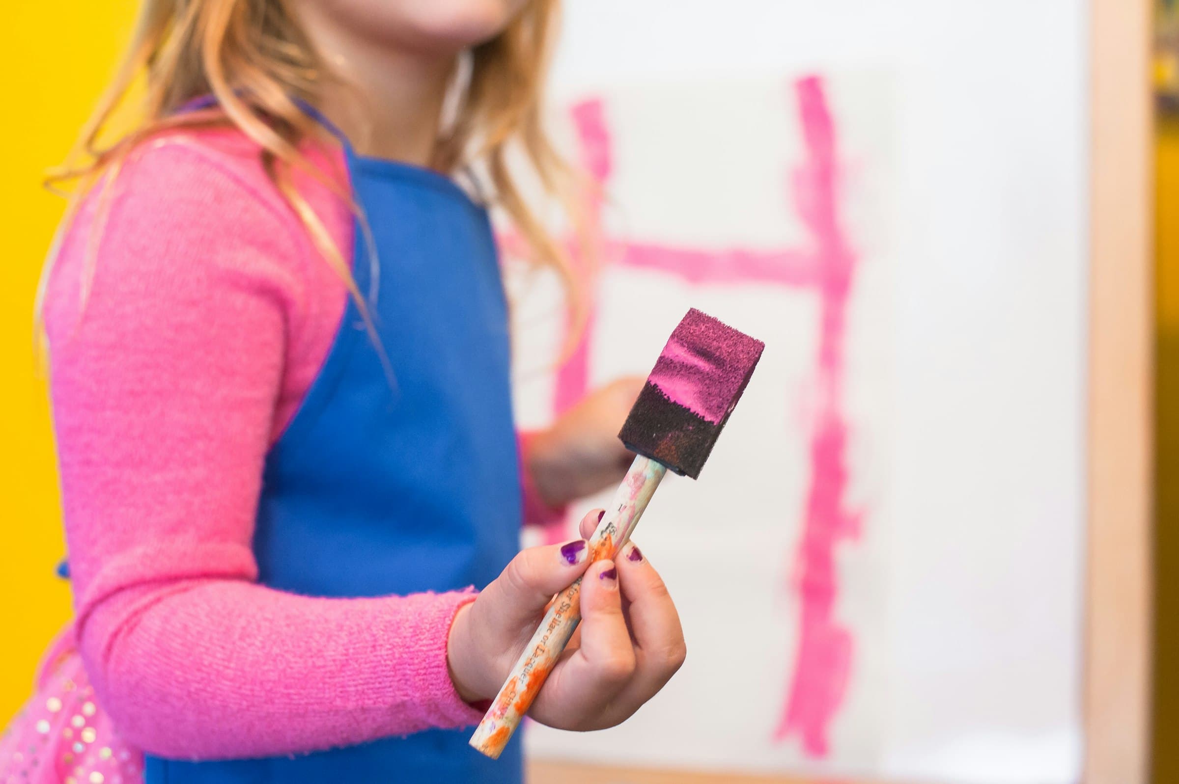 A child painting with a wide brush