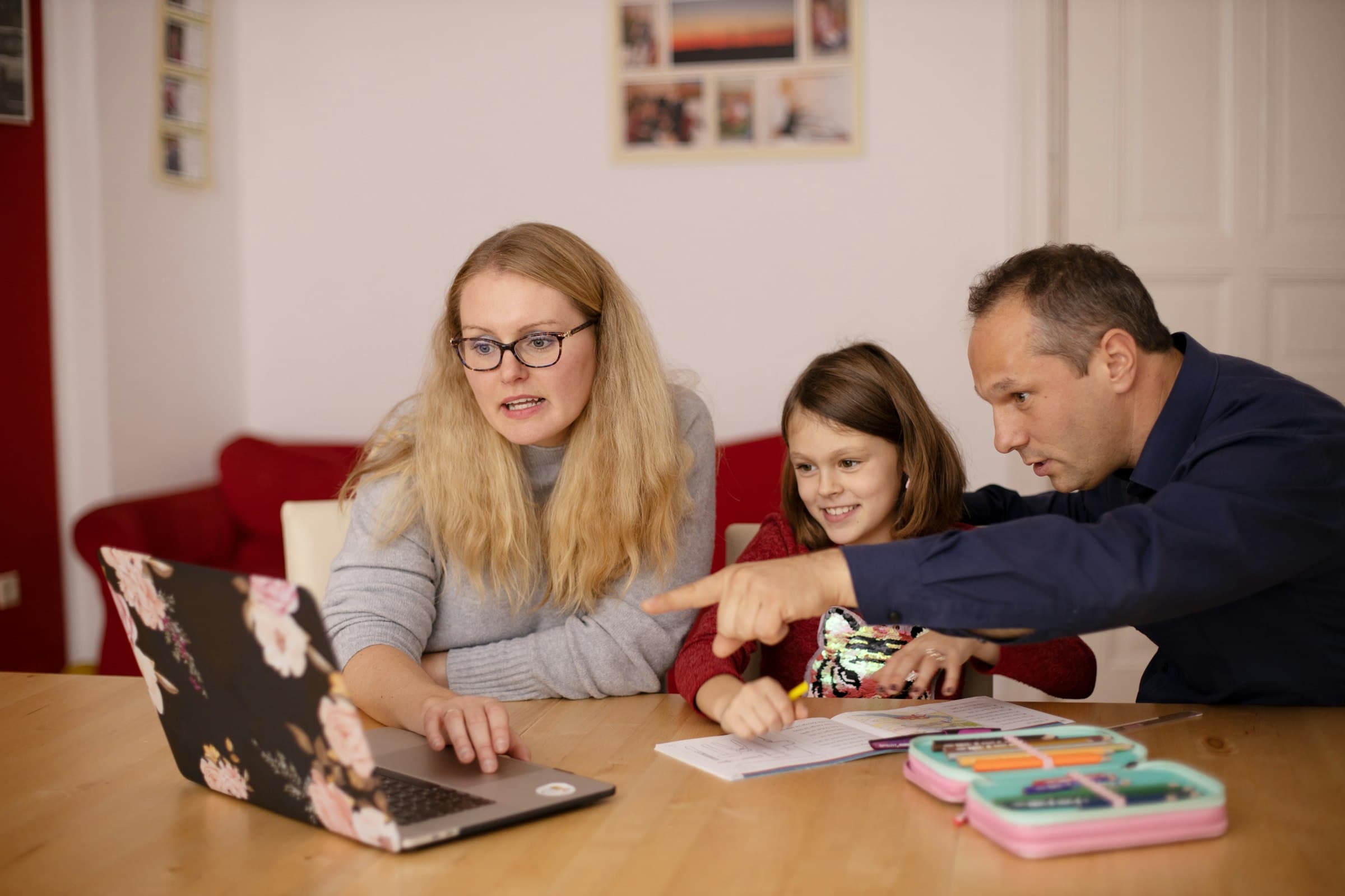 A young child and an adult seated together at a low table, working through an activity
